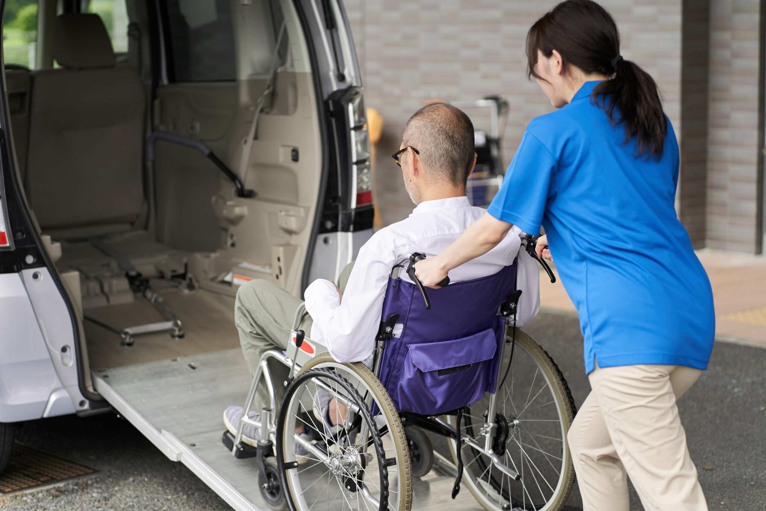 Caregiver helping elderly patient - Non-Emergency Medical Transportation